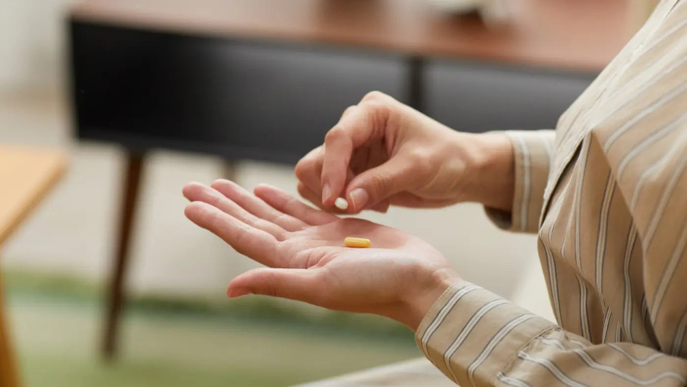 Frau in gestreifter Bluse hält Resveratrol und nmn-Tablette