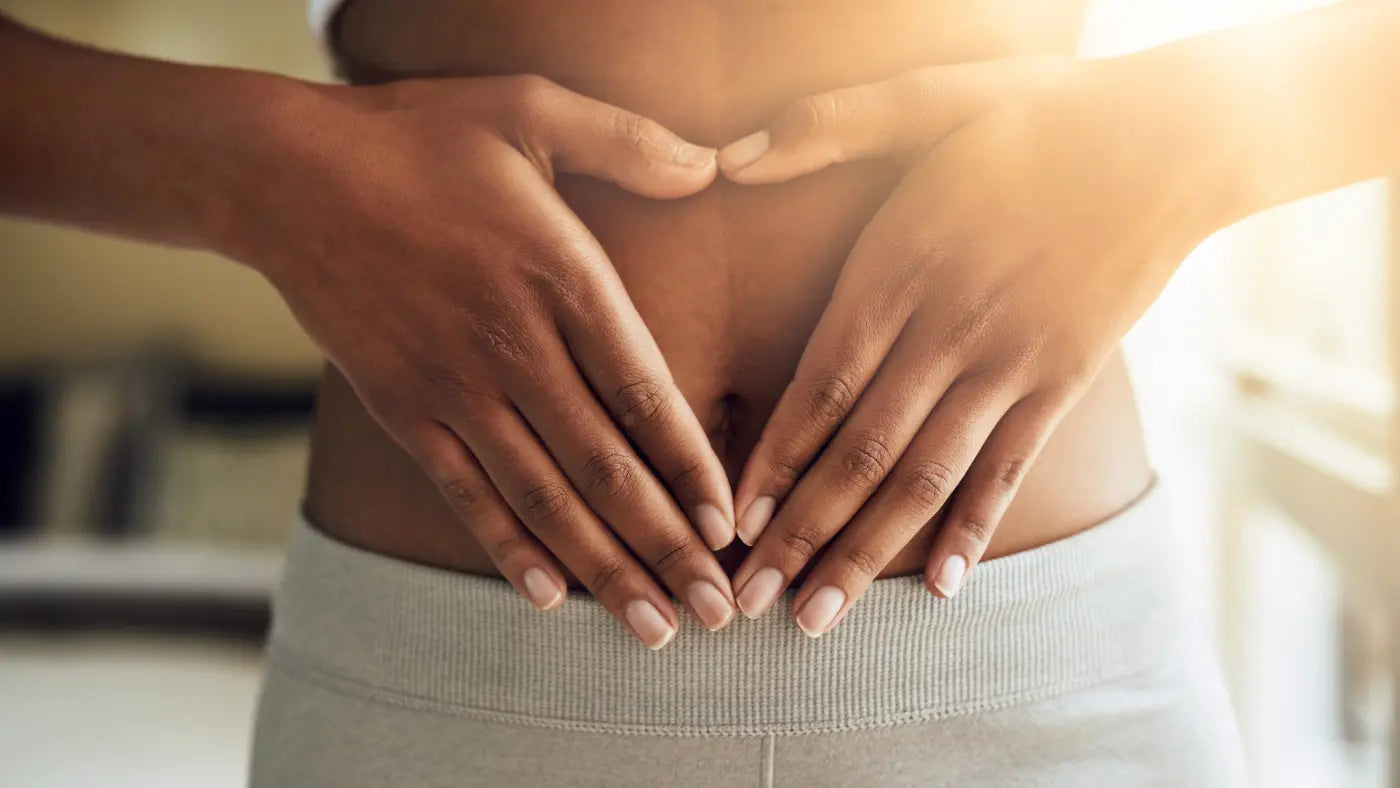 Frau legt Hände auf ihren Bauch 